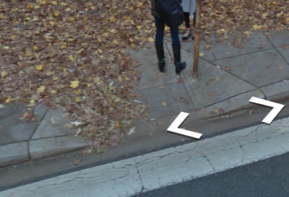 A Street View image of a curb ramp with light debris