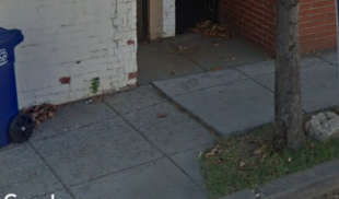 A Street View image of a sidewalk with a small elevation change